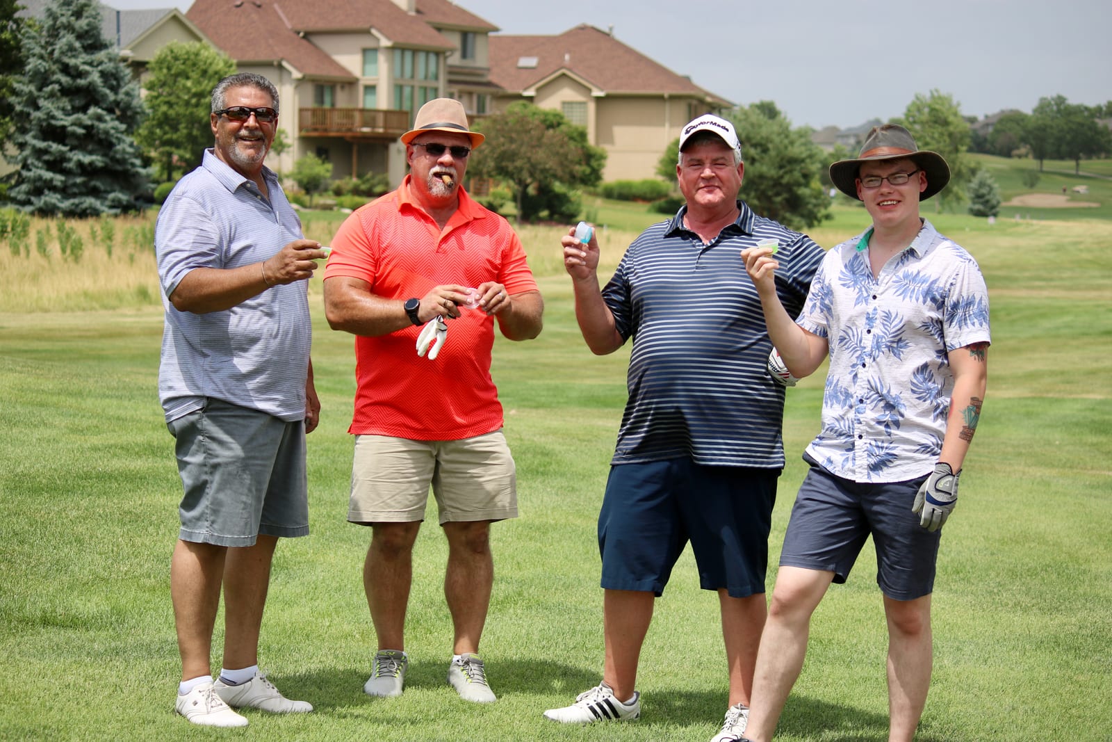 Golf scramble participants standing between golf carts at Eagle Hills Golf Course