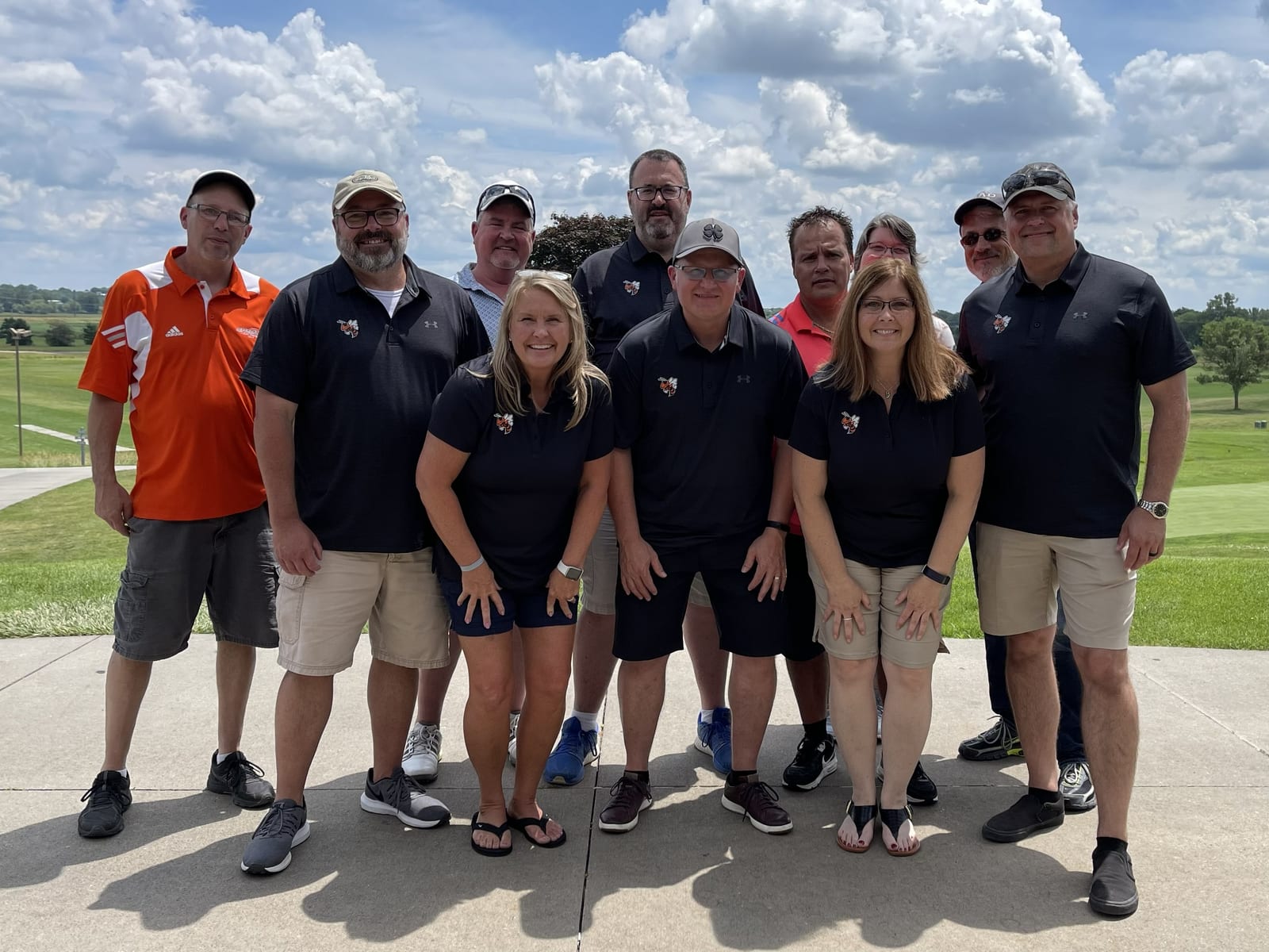 Golf scramble participants standing between golf carts at Eagle Hills Golf Course